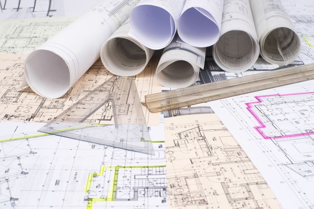 Architectural drawings and blueprints on a table.
