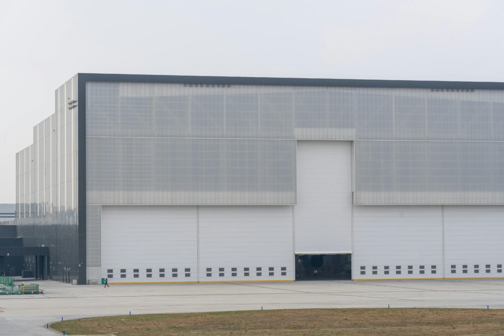 Front view of a large modern warehouse with closed doors, showcasing industrial architecture